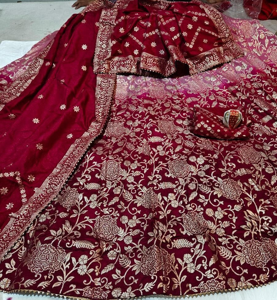 A luxurious maroon Banarasi Dolo silk lehenga choli set featuring intricate golden zari floral embroidery and a designer dupatta.