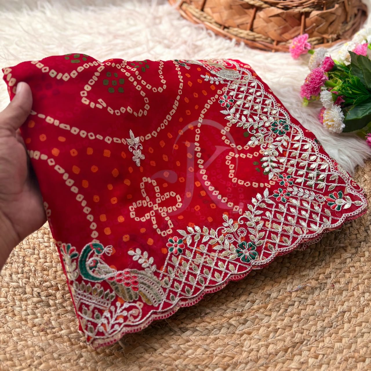 Red Bandhani Georgette Saree With Gota Patti Work 2 A beautiful red Bandhani georgette saree with intricate gota patti work paired with a contrast green blouse on a textured background.