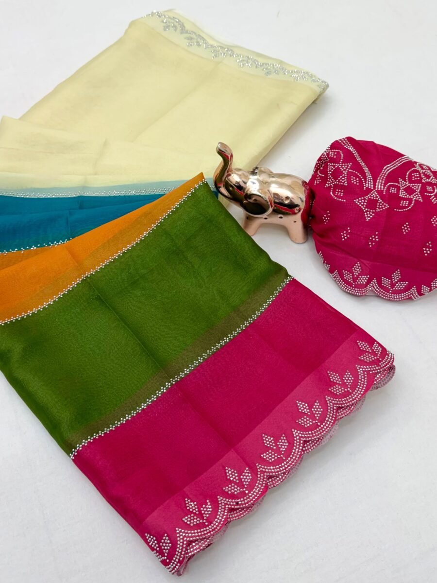 A colorful multi-paneled silk saree with a silver diamond-studded cut-work border, displayed with a matching blouse piece and a small decorative elephant figurine.