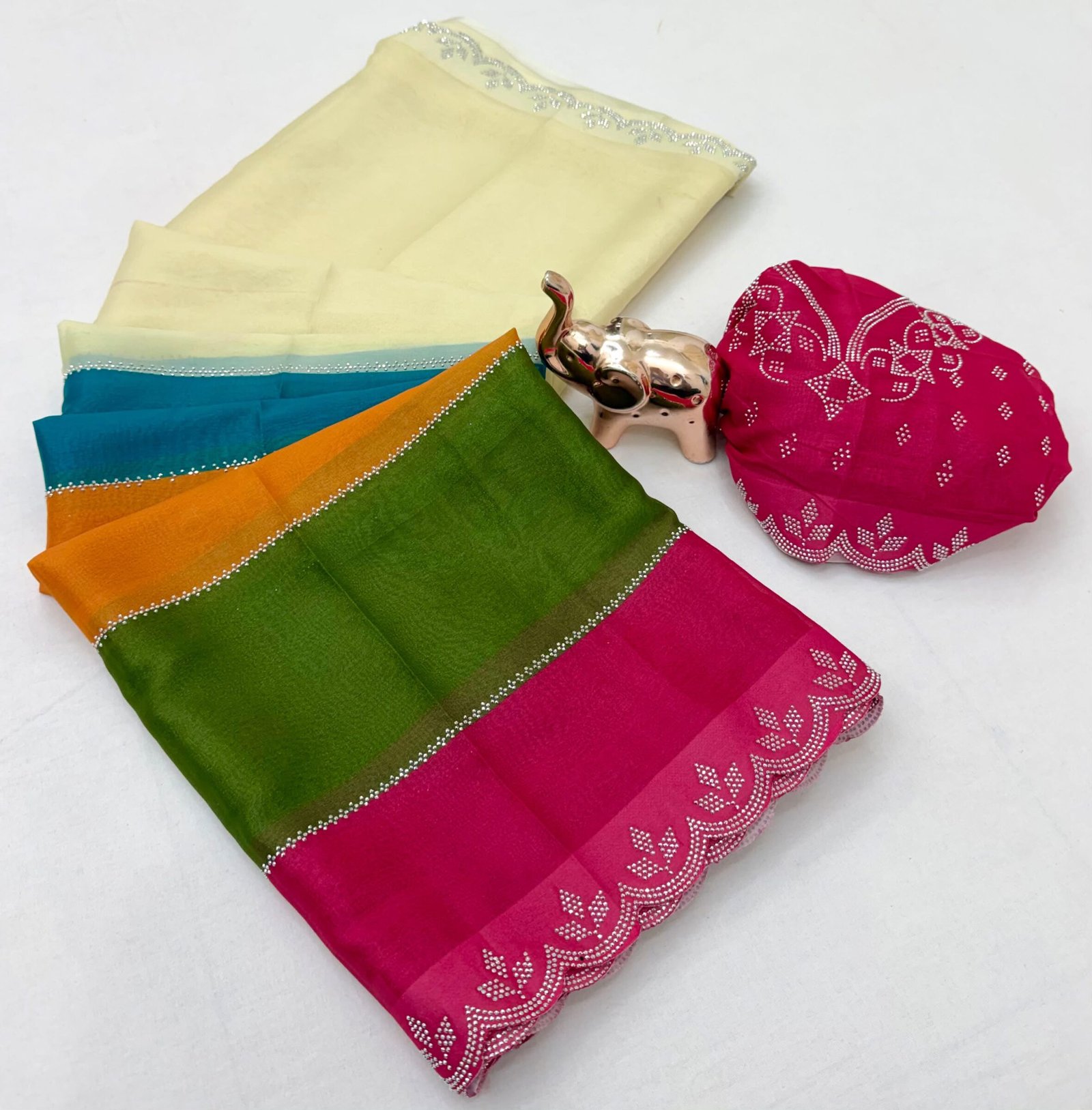 Diamond Panel Work Rich Silk Saree with Fancy Cut Work 1 A colorful multi-paneled silk saree with a silver diamond-studded cut-work border, displayed with a matching blouse piece and a small decorative elephant figurine.