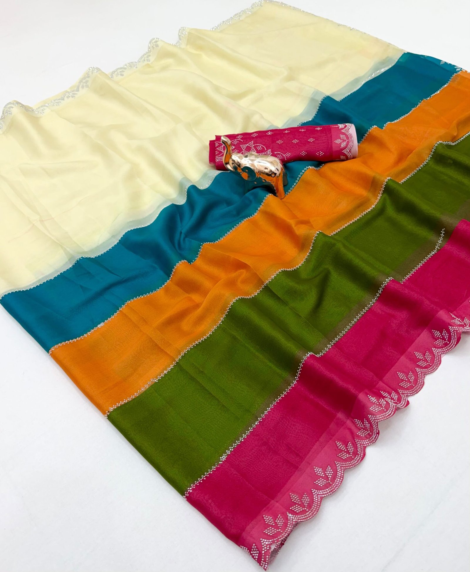 Diamond Panel Work Rich Silk Saree with Fancy Cut Work 3 A colorful multi-paneled silk saree with a silver diamond-studded cut-work border, displayed with a matching blouse piece and a small decorative elephant figurine.