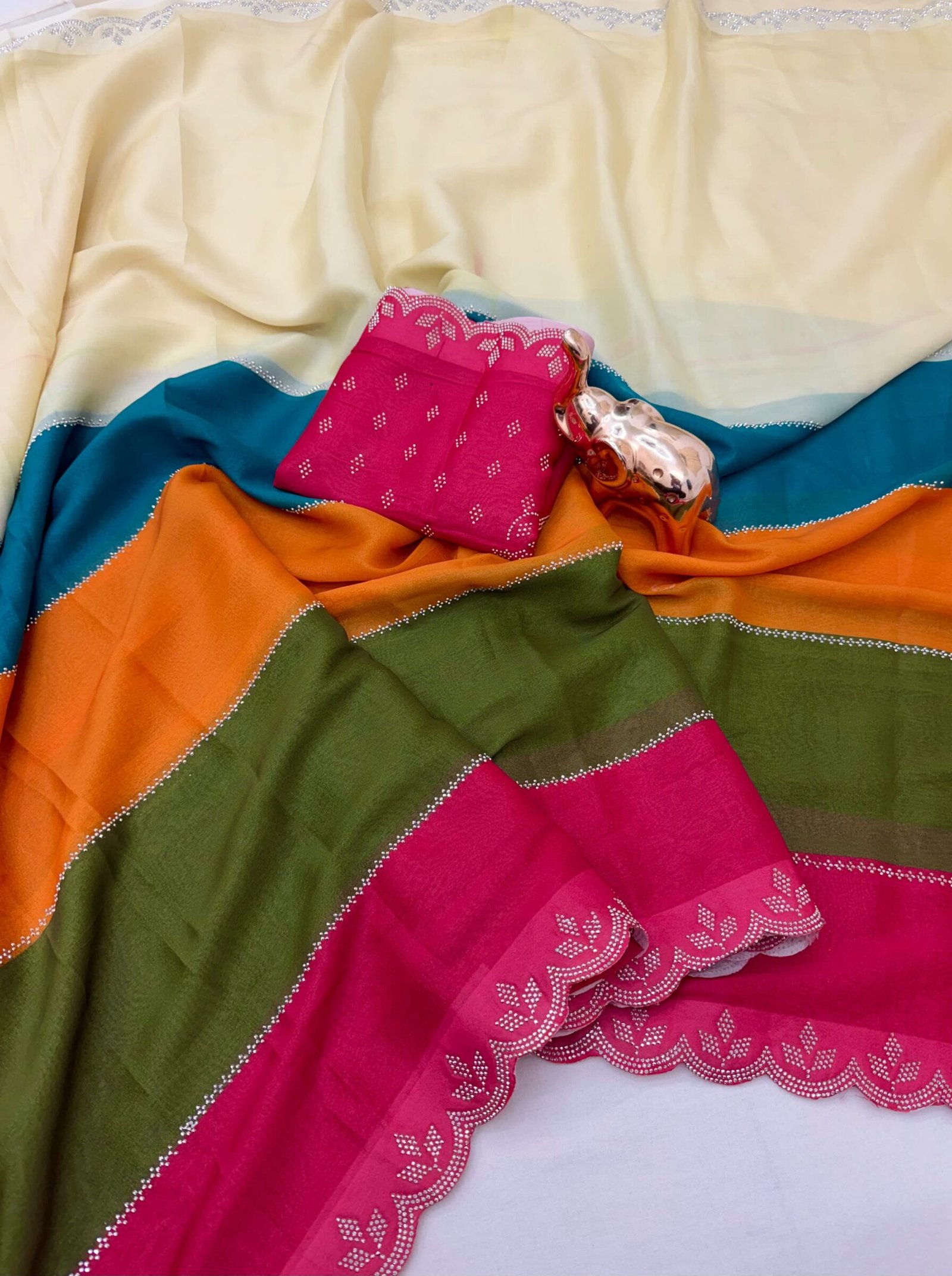 Diamond Panel Work Rich Silk Saree with Fancy Cut Work 4 A colorful multi-paneled silk saree with a silver diamond-studded cut-work border, displayed with a matching blouse piece and a small decorative elephant figurine.
