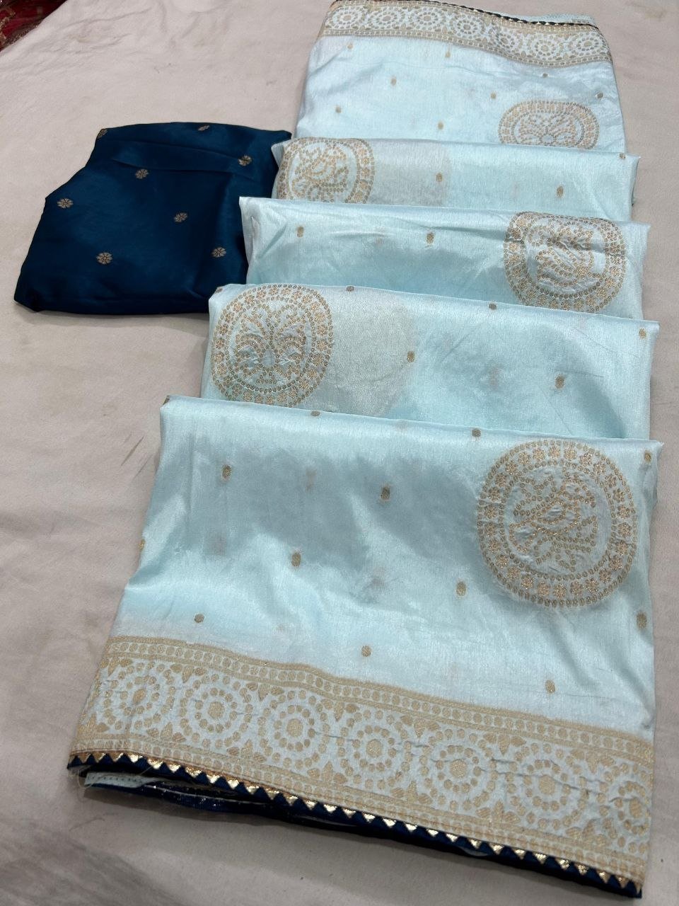 Deep Purple Dola Silk Zari Work Saree | Kanha Saree 2 A flat-lay view of a deep purple Dola silk saree featuring gold zari work and a contrasting red blouse piece.