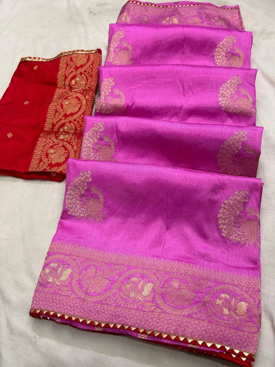 Deep Purple Dola Silk Saree with Peacock Zari Work 3 A beautiful deep purple Dola silk saree displayed in folds, showcasing gold zari peacock motifs and an ornate zari border.