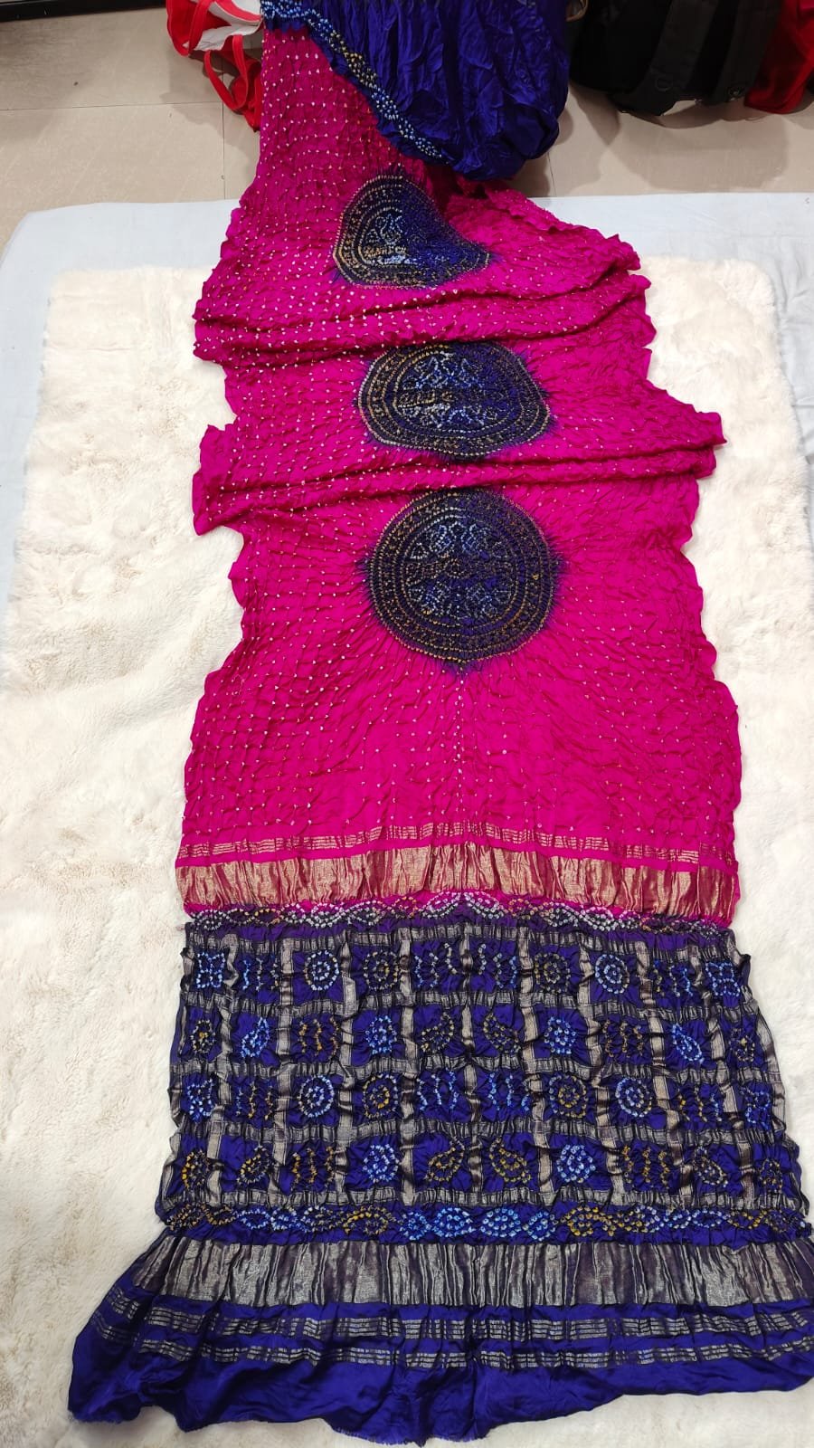 Pure Gajji Moddal Silk Bandhej Saree with Zari Pallu 1 A beautiful bright pink Bandhej saree made from pure gajji moddal silk with a deep blue zari pallu displayed on a soft white background.