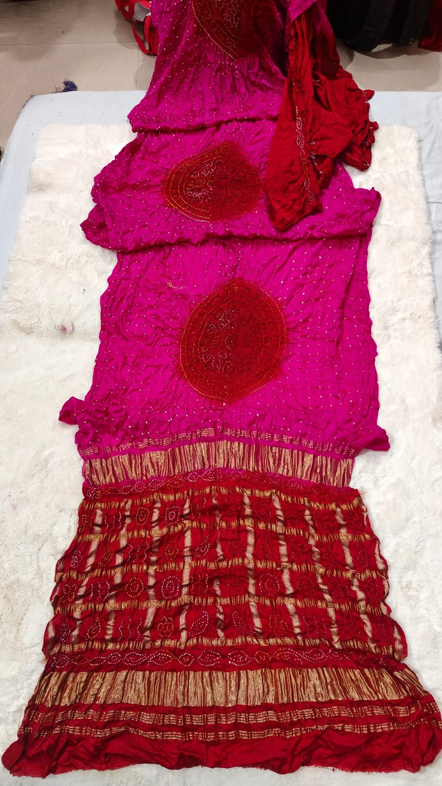 Pure Gajji Moddal Silk Bandhej Saree with Zari Pallu 4 A beautiful bright pink Bandhej saree made from pure gajji moddal silk with a deep blue zari pallu displayed on a soft white background.