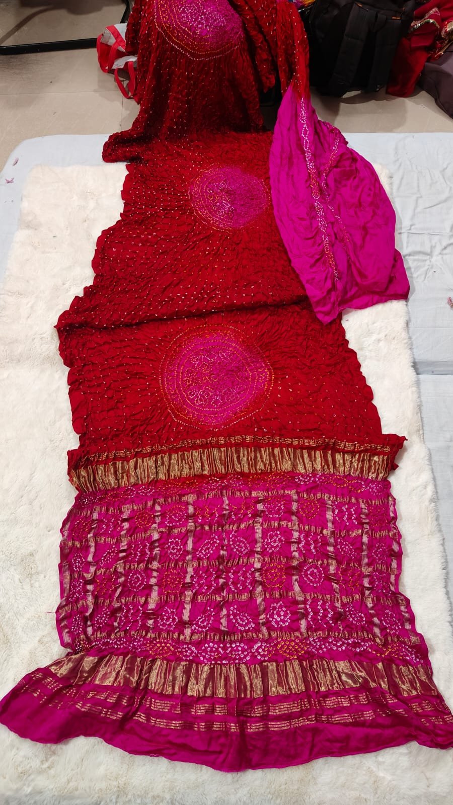 Pure Gajji Moddal Silk Bandhej Saree with Zari Pallu 5 A beautiful bright pink Bandhej saree made from pure gajji moddal silk with a deep blue zari pallu displayed on a soft white background.
