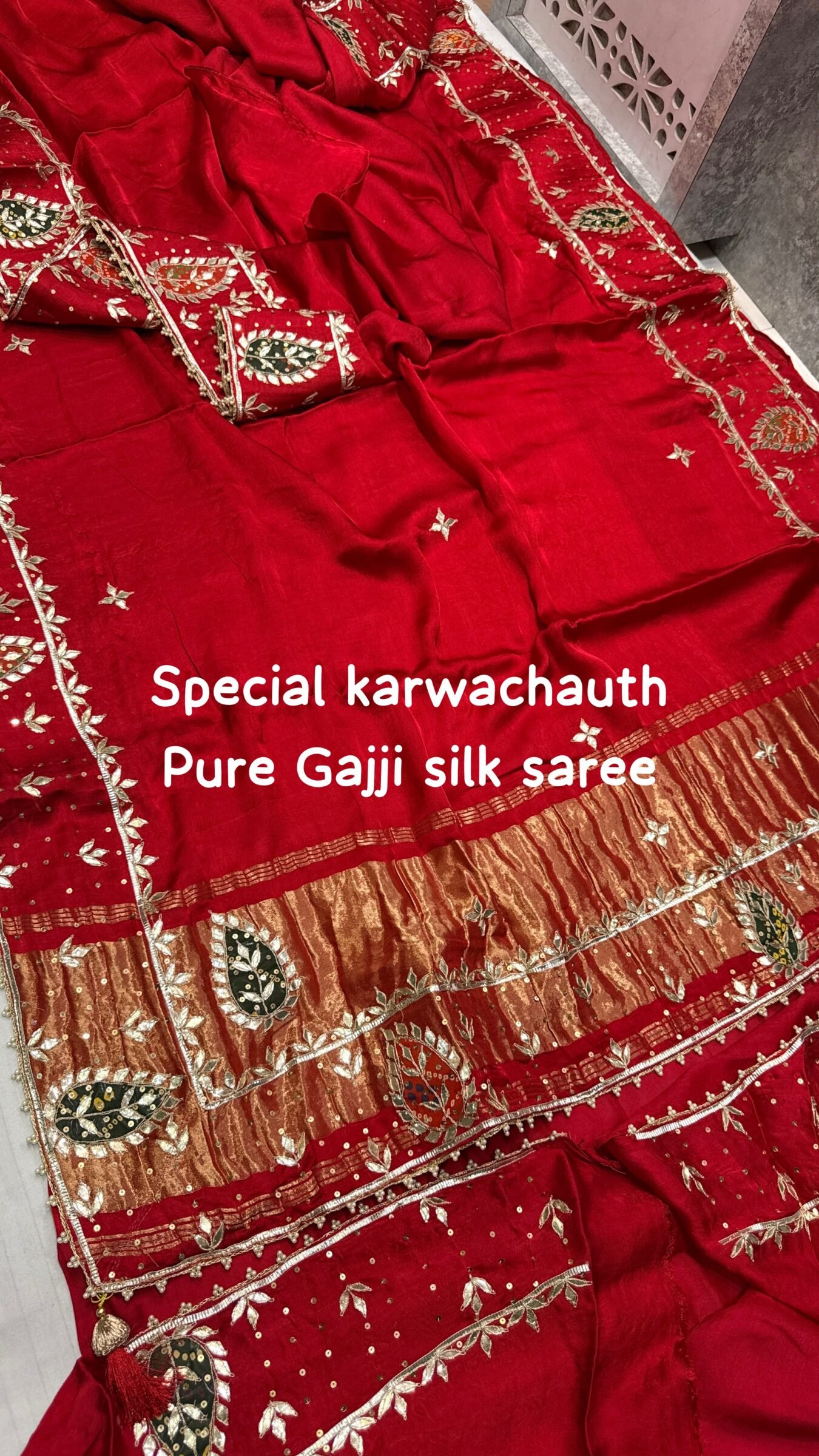 Pure Gajji Silk Saree with Hand Gota Patti Work 3 A close-up view of a vibrant red pure Gajji Silk saree featuring detailed hand Gota Patti Keri work and a decorative designer border.