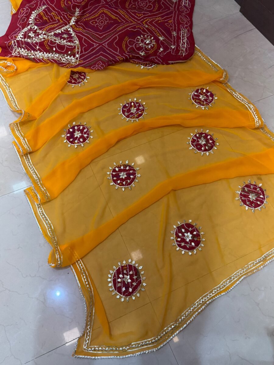 A beautiful yellow georgette saree featuring red bandhani patches and detailed gold kachi gota work along the border.