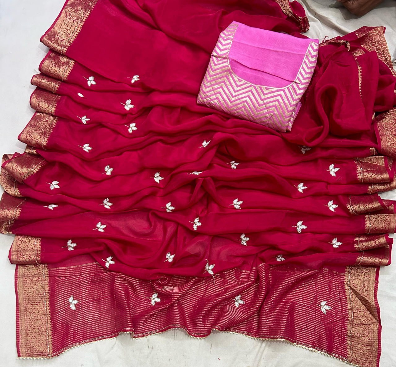 H.O. Silk Saree with Elegant Zari Border 1 A luxurious H.O. Silk saree in a deep red shade with intricate embroidery and a traditional zari border.