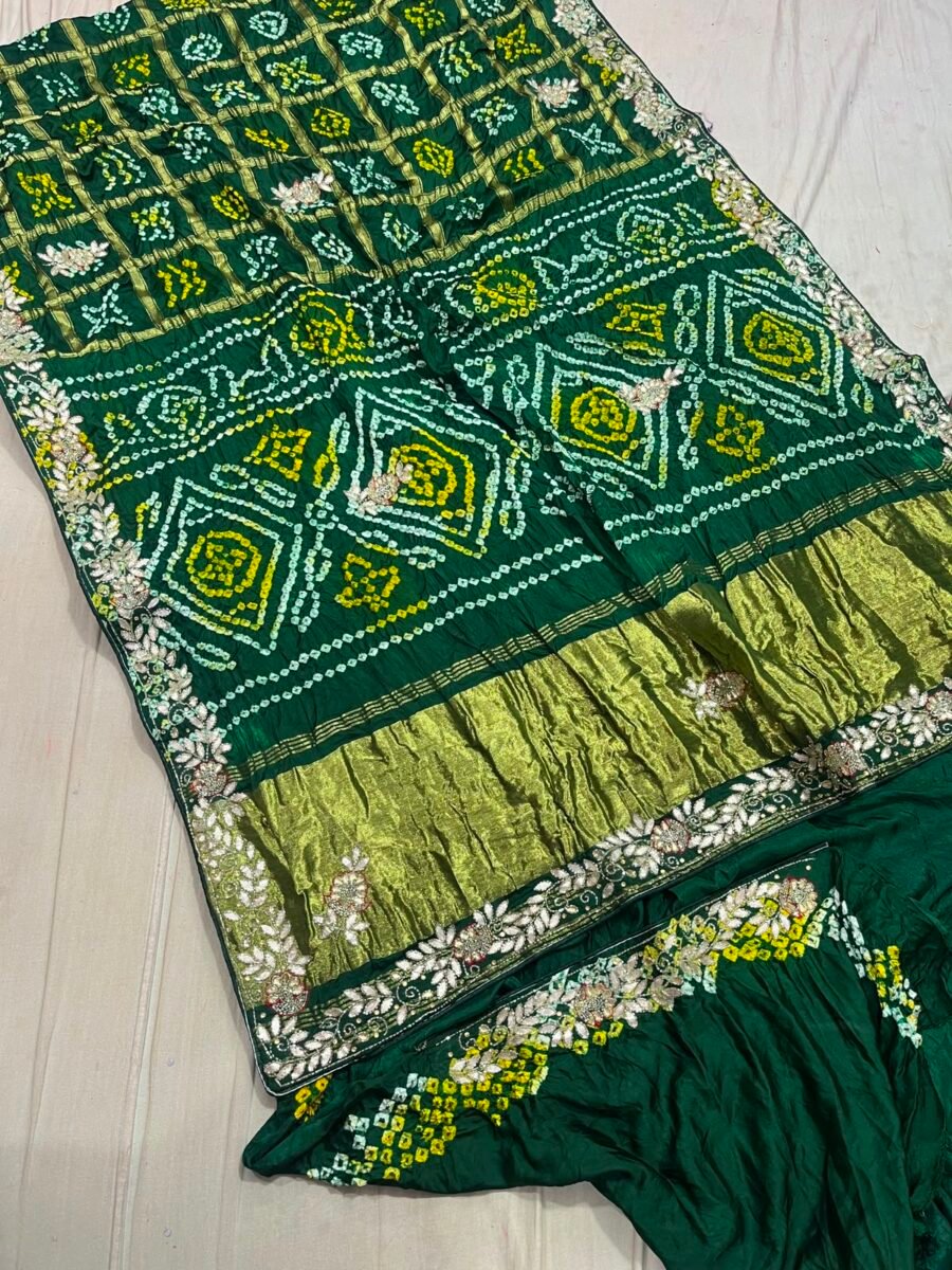 A dark green Modal Gaji Ghatchola saree with yellow block patterns and intricate gold Zardozi handwork borders laid out on a white surface.