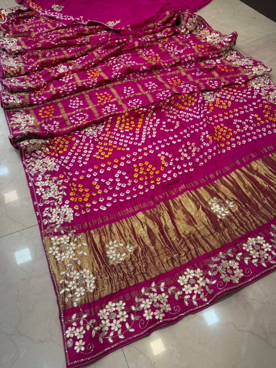 A close-up of a pink Modal Gaji Ghatchola saree with intricate gold Zardozi and Dabka hand work on the border.