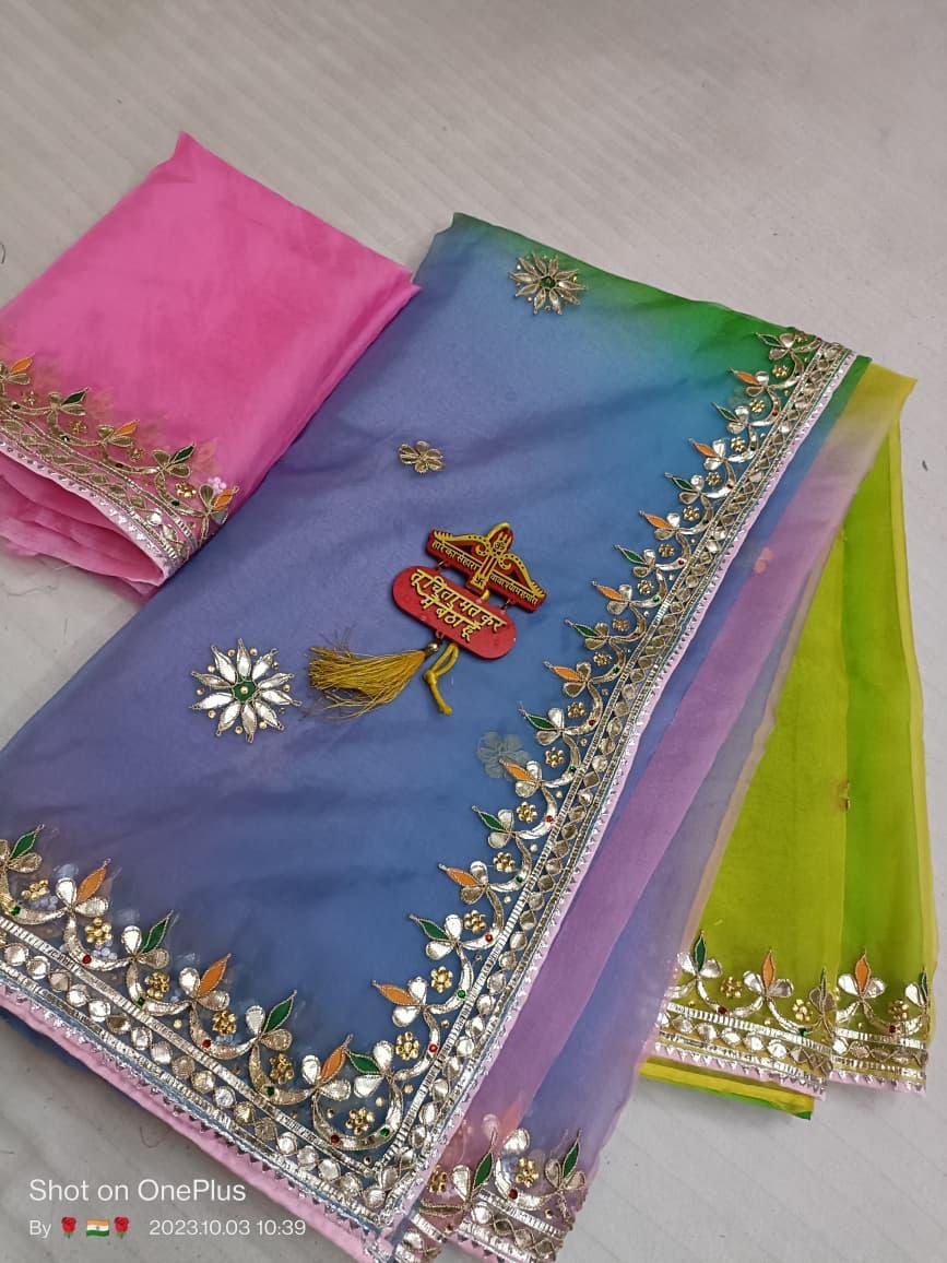 A beautiful multi-colored Pure Organza saree with Gota Patti border and floral buta work, laid out with a matching pink blouse piece.