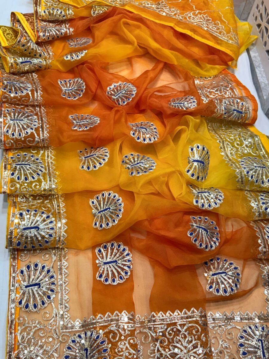 A beautiful yellow and orange shaded pure organza saree adorned with intricate silver Gota Patti work and floral motifs.