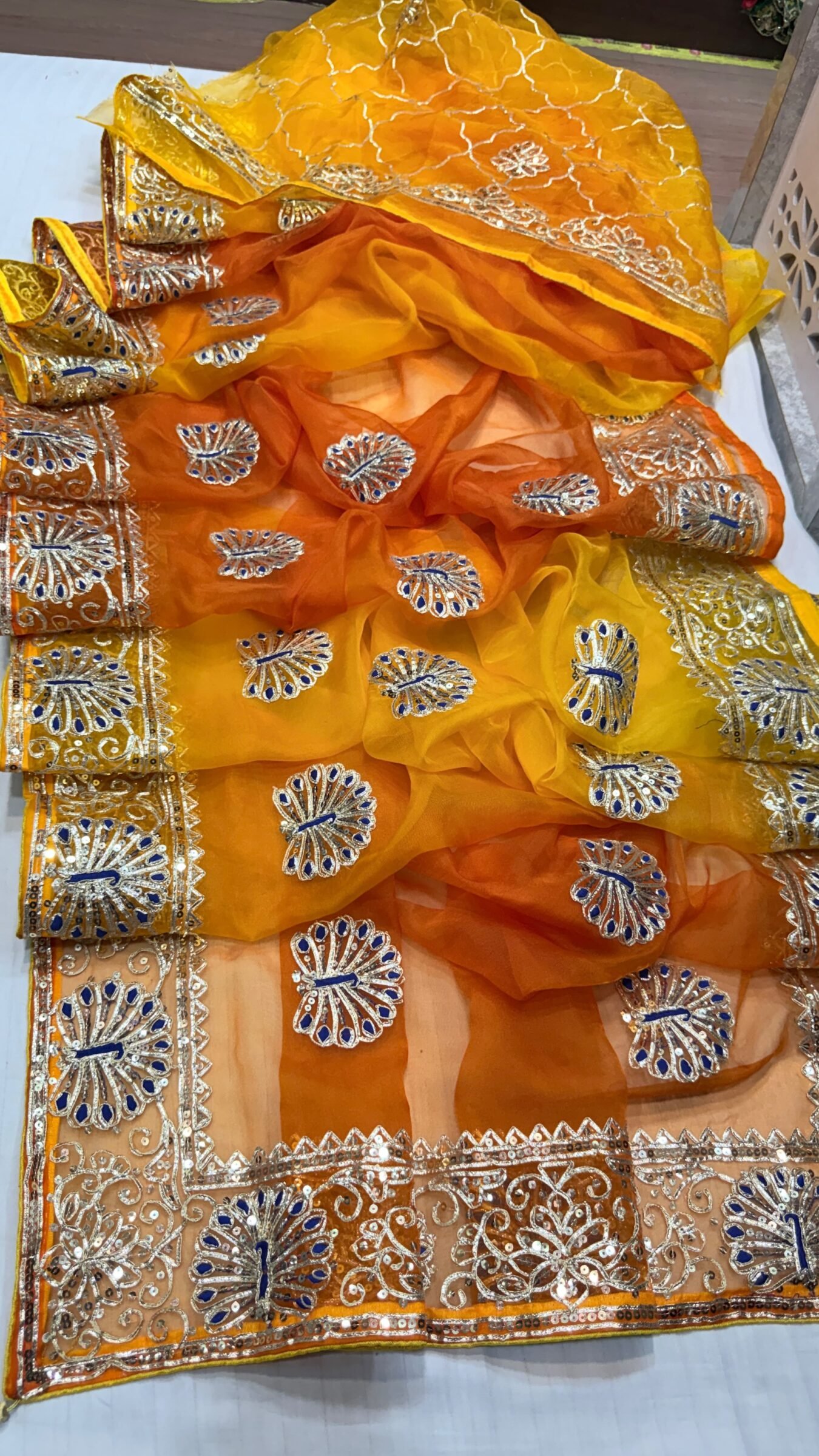 Pure Organza Gota Patti Saree | Designer Ethnic Wear 1 A beautiful yellow and orange shaded pure organza saree adorned with intricate silver Gota Patti work and floral motifs.