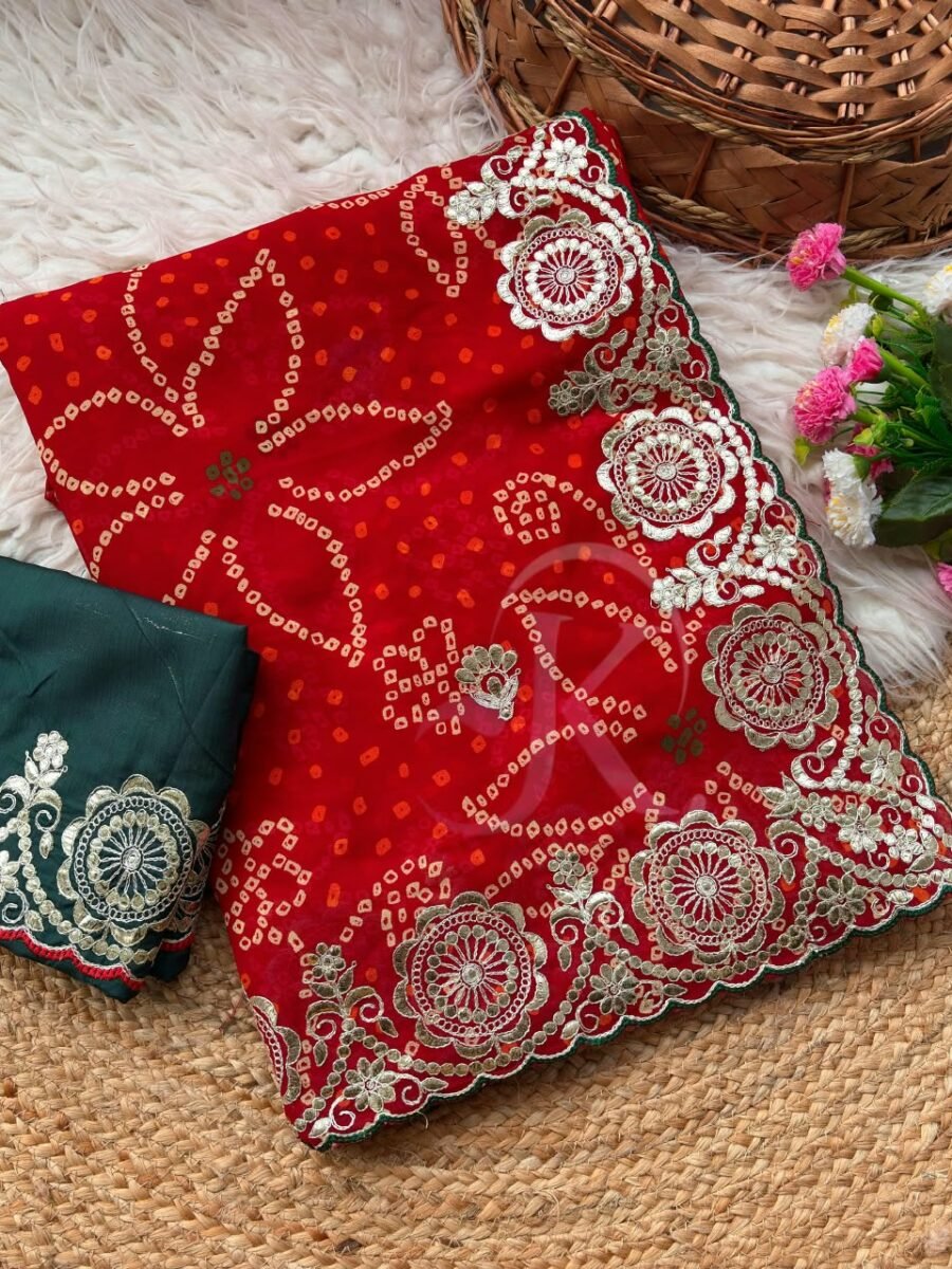 A vibrant red Bandhani saree with intricate gold Gota Patti border work paired with a dark green embroidered blouse.