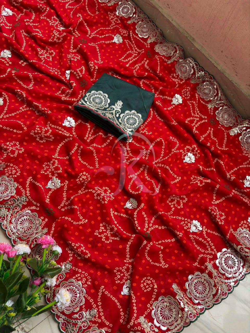 Red Bandhani Saree with Gota Patti Work 2 A vibrant red Bandhani saree with intricate gold Gota Patti border work paired with a dark green embroidered blouse.