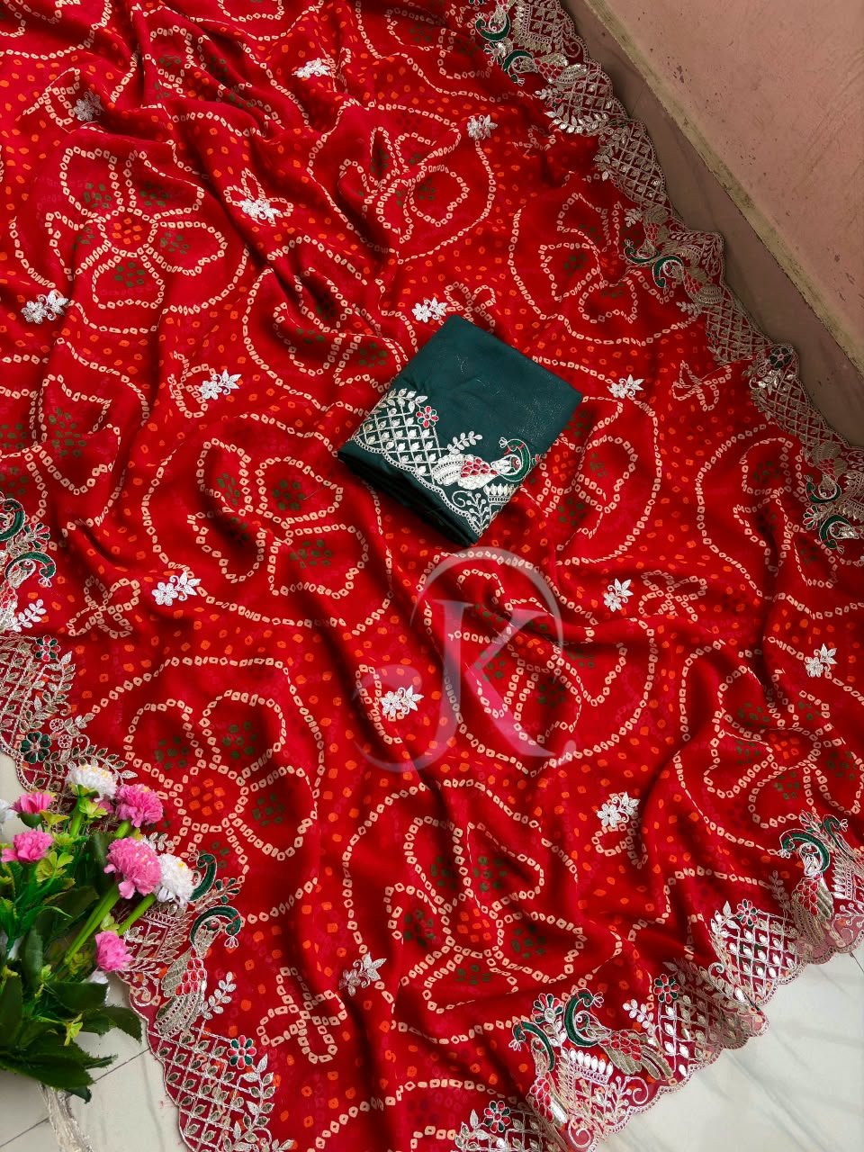 Red Bandhani Saree with Gota Patti Work 5 A vibrant red Bandhani saree with intricate gold Gota Patti border work paired with a dark green embroidered blouse.