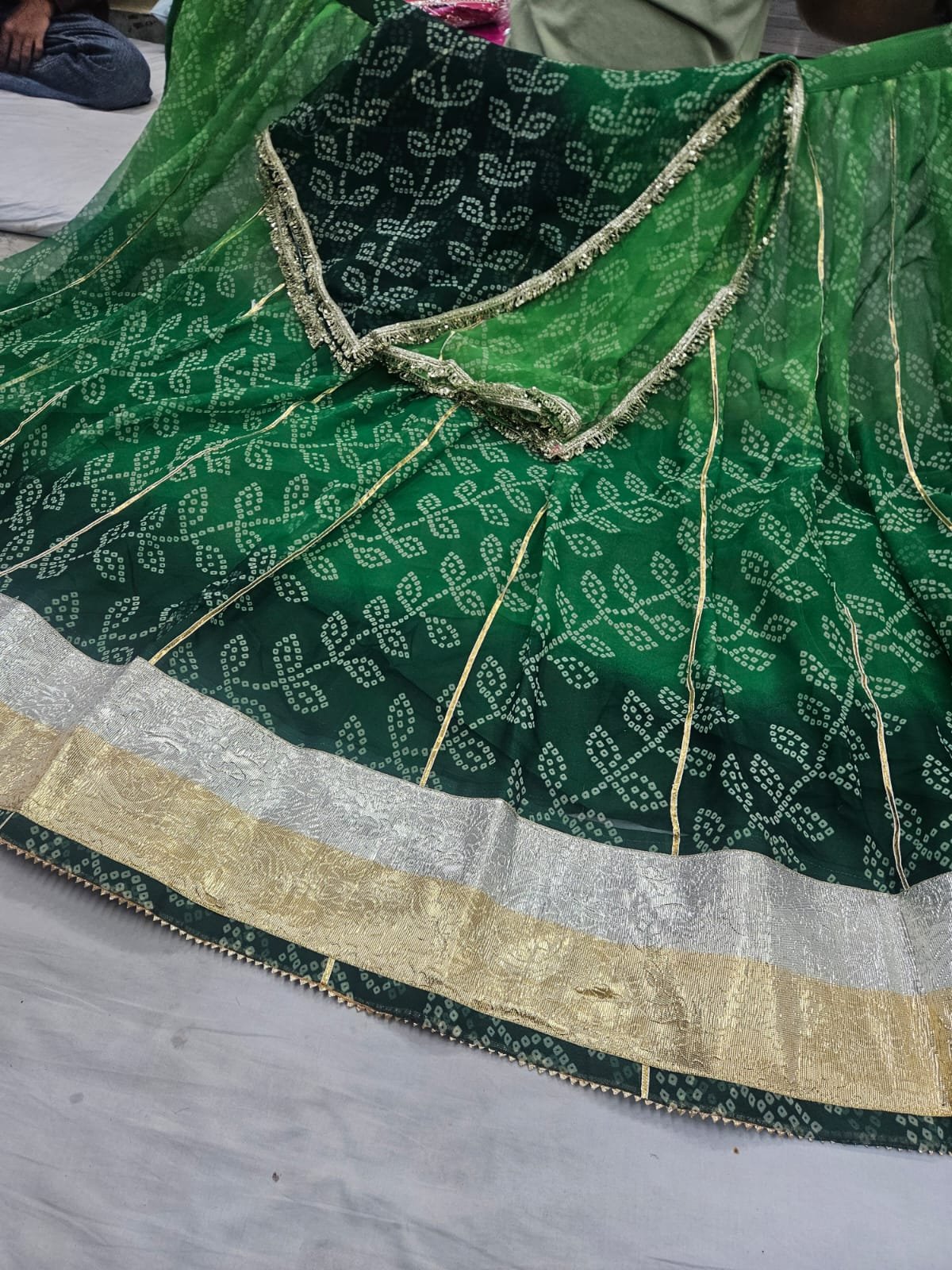 Royal Jorjet Bandhani Lehenga with Lappa Lace Border 3 A yellow and orange Bandhani lehenga featuring a wide silver and gold Lappa lace border on display.