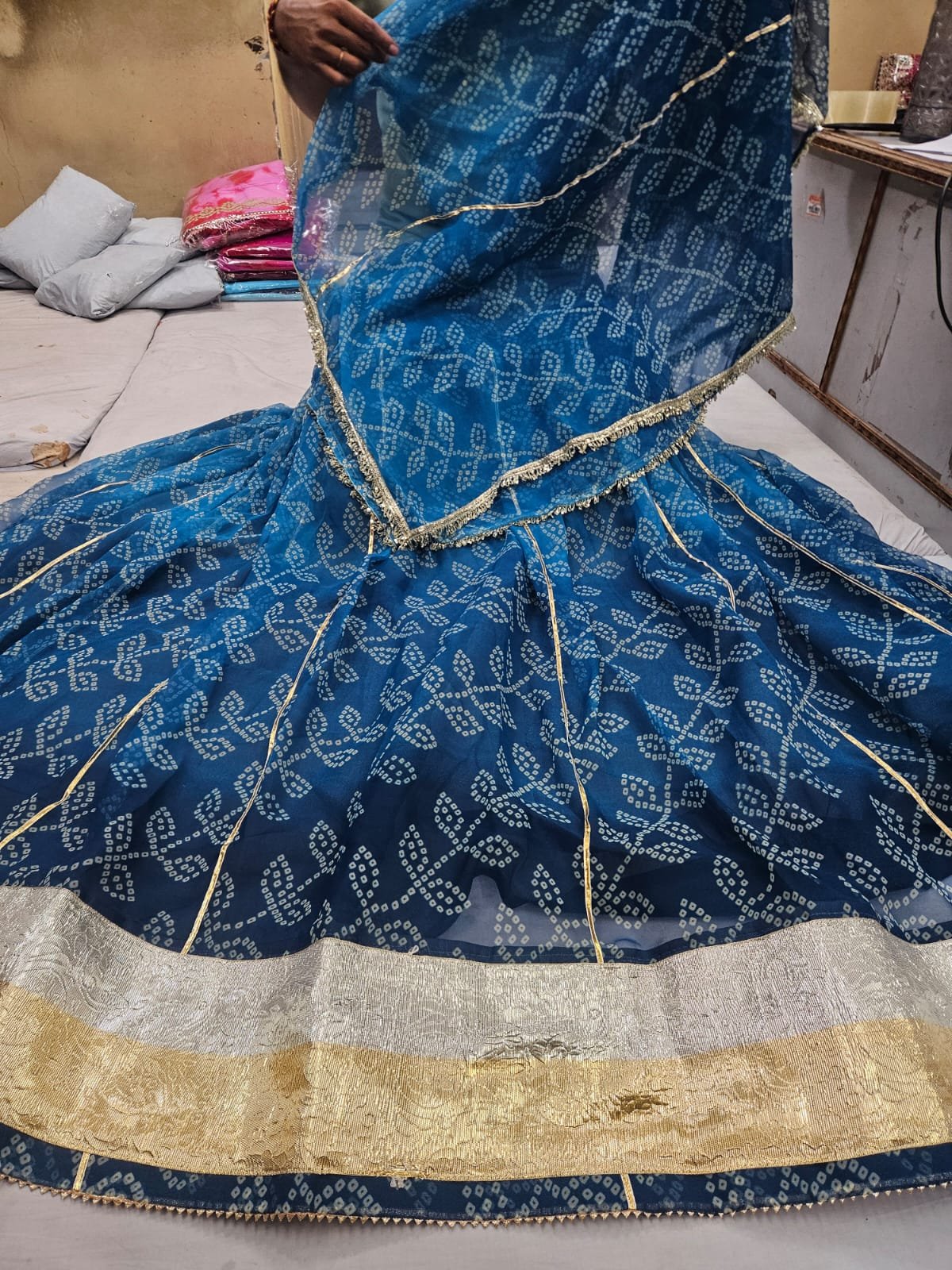 Royal Jorjet Bandhani Lehenga with Lappa Lace Border 4 A yellow and orange Bandhani lehenga featuring a wide silver and gold Lappa lace border on display.
