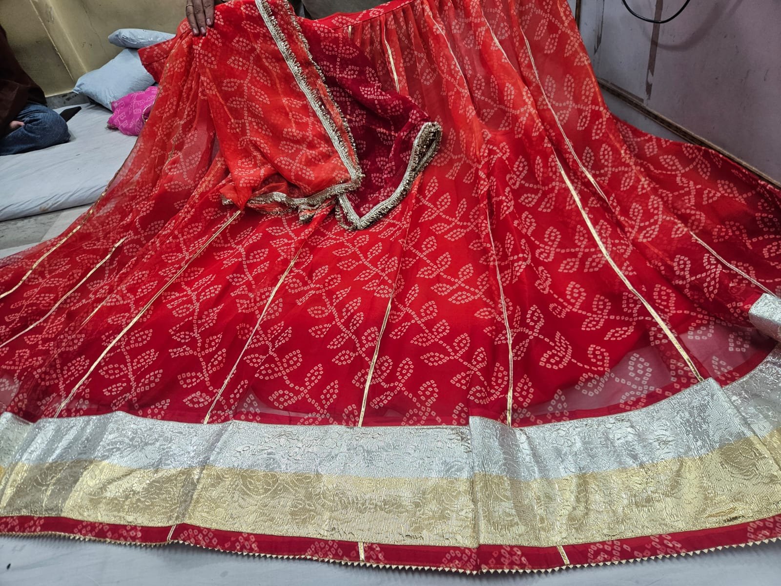 Royal Jorjet Bandhani Lehenga with Lappa Lace Border 5 A yellow and orange Bandhani lehenga featuring a wide silver and gold Lappa lace border on display.