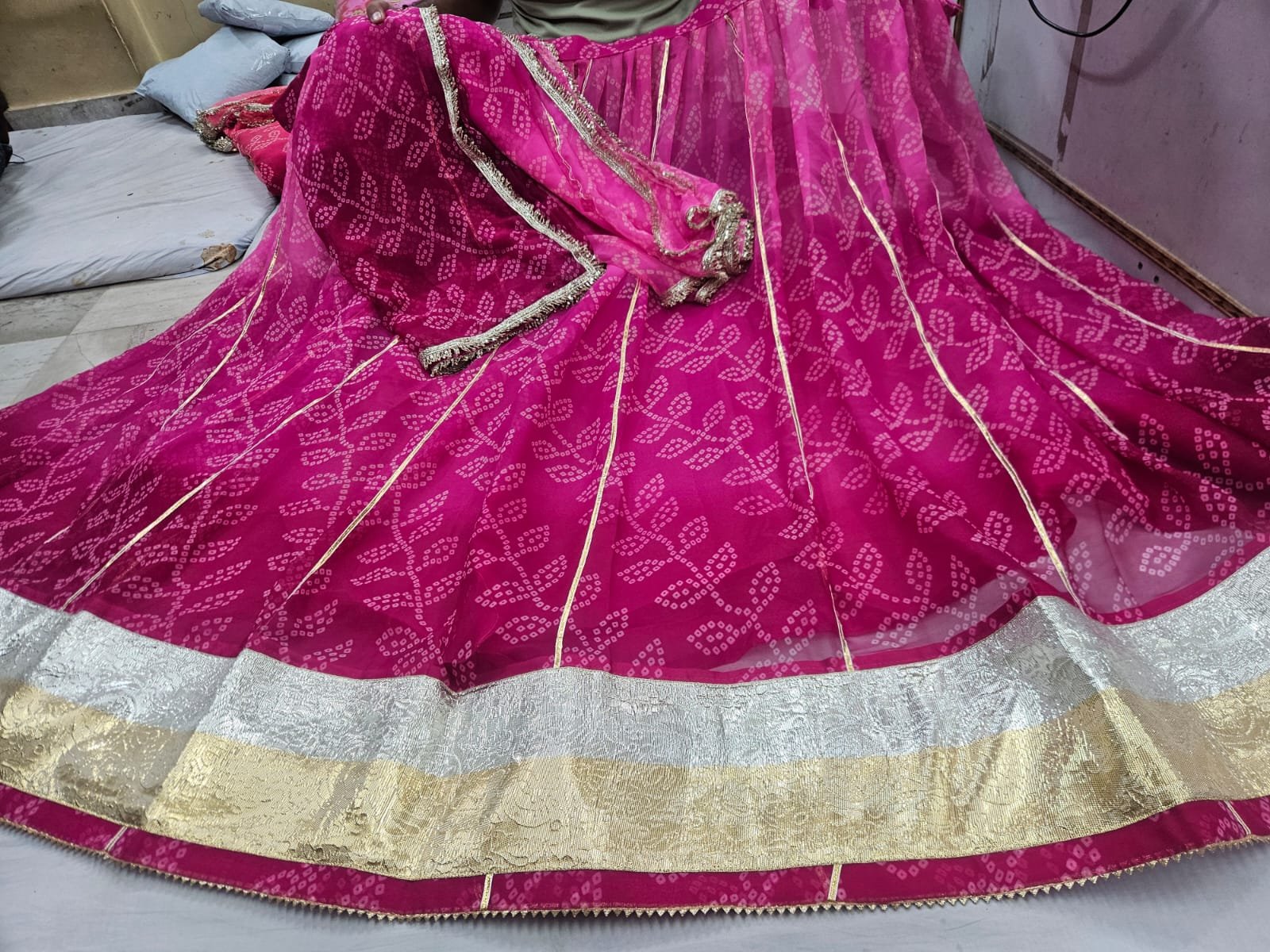 Royal Jorjet Bandhani Lehenga with Lappa Lace Border 6 A yellow and orange Bandhani lehenga featuring a wide silver and gold Lappa lace border on display.