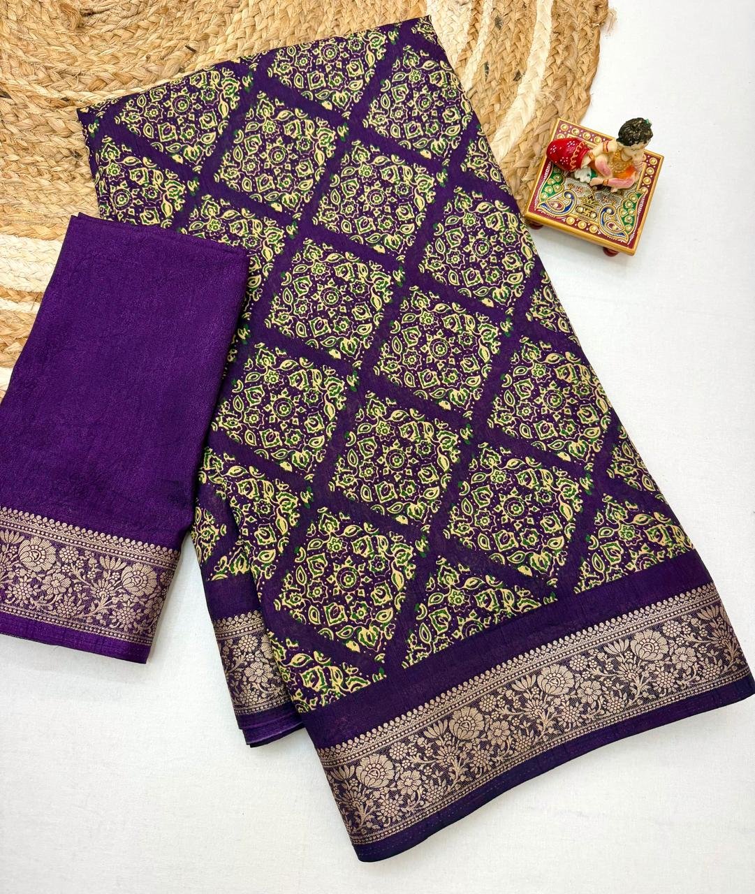 Soft Dola Weaving Saree with Jacquard Border 5 A navy blue Soft Dola weaving saree with an intricate golden jacquard border and a matching blouse piece on a jute mat.