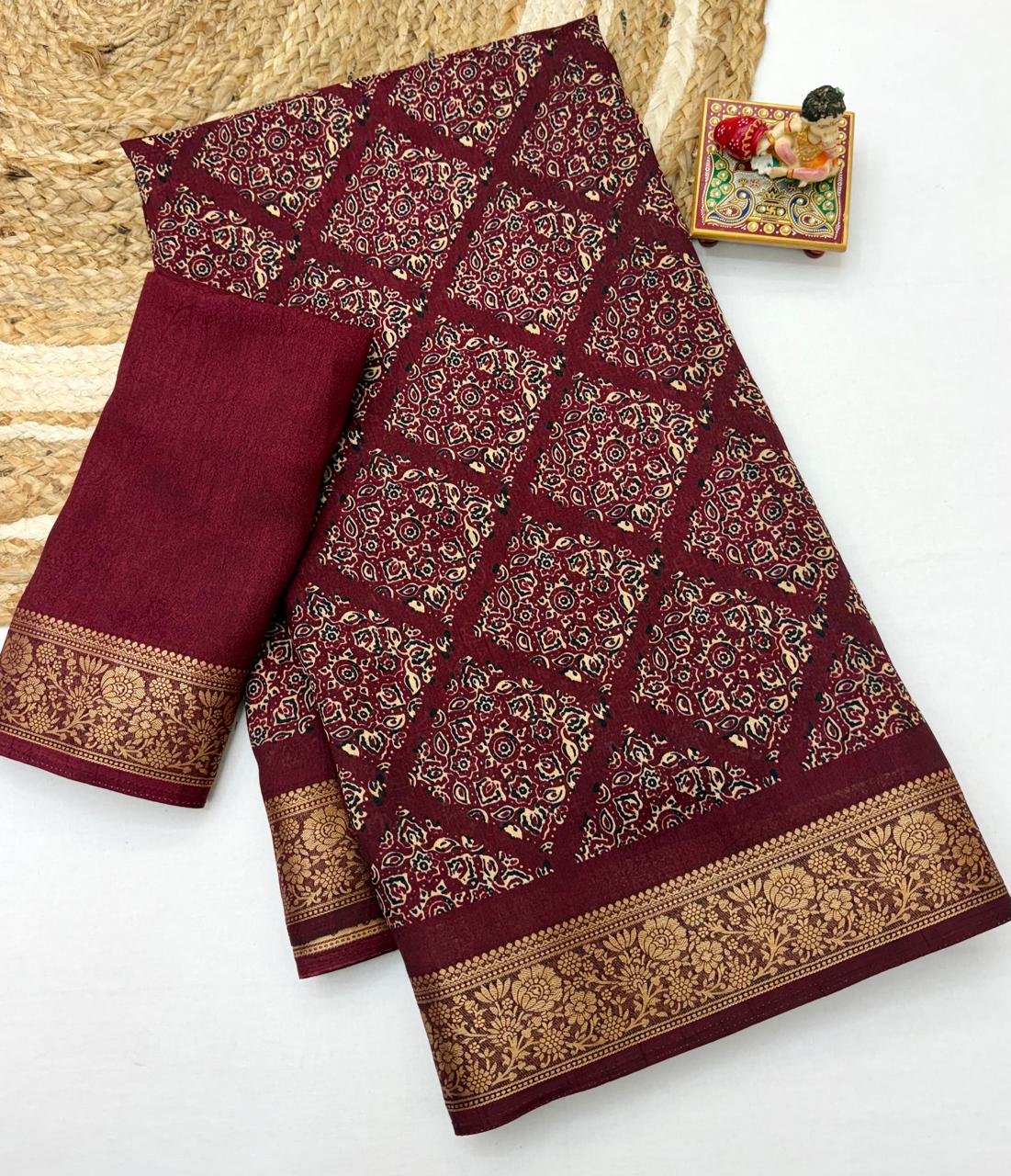 Soft Dola Weaving Saree with Jacquard Border 6 A navy blue Soft Dola weaving saree with an intricate golden jacquard border and a matching blouse piece on a jute mat.