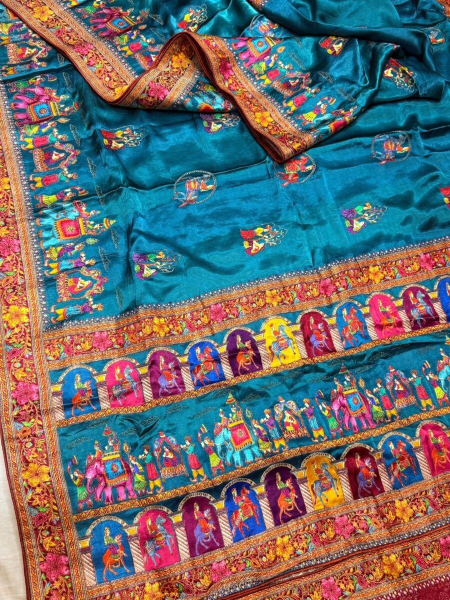 A beautiful teal tissue silk saree featuring intricate golden zari work, traditional raj darbari motifs, and a matching embroidered blouse.