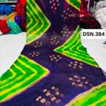A person holding up a vibrant art silk Bandhani saree with geometric patterns and bright tie-dye work.