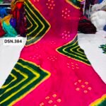 A person holding up a vibrant art silk Bandhani saree with geometric patterns and bright tie-dye work.