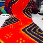 A person holding up a vibrant art silk Bandhani saree with geometric patterns and bright tie-dye work.