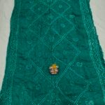A beautiful deep maroon Art Silk Rai Bandhej Saree displayed with a small idol placed on top to highlight its intricate patterned texture.