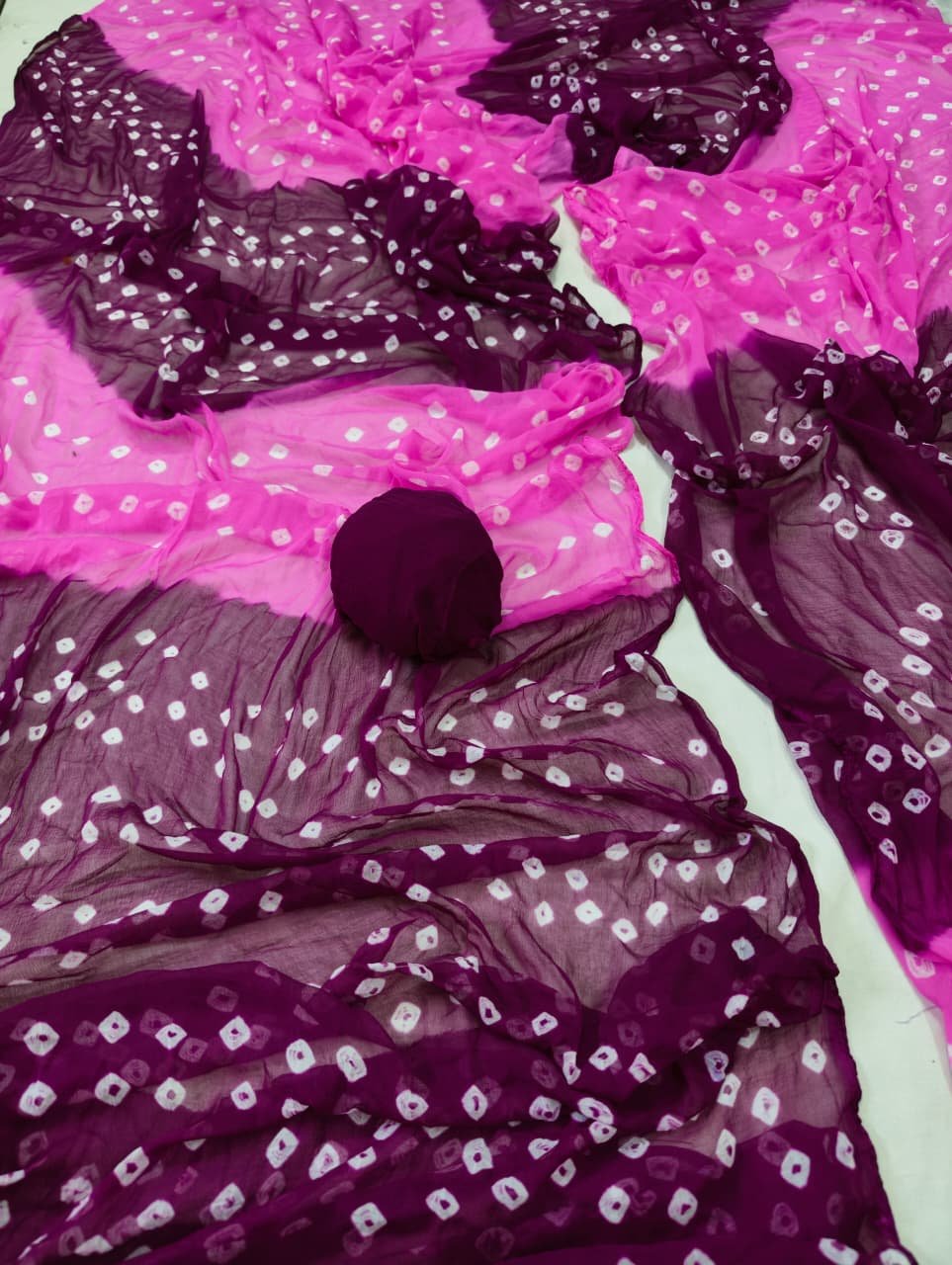Nazneen Chiffon Bandhani Saree 9 A close-up of a Nazneen Chiffon Bandhani Saree featuring vibrant red and yellow tie and dye patterns.