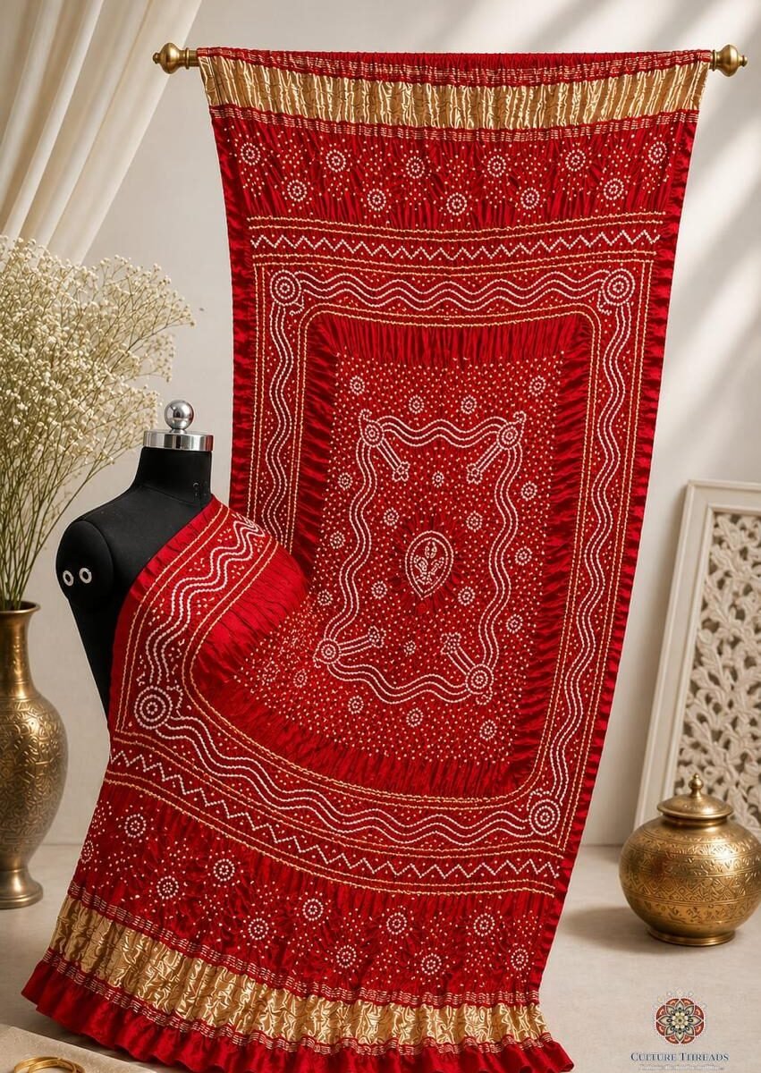 A red pure Gajji silk Bandhani dupatta with gold borders displayed on a mannequin.