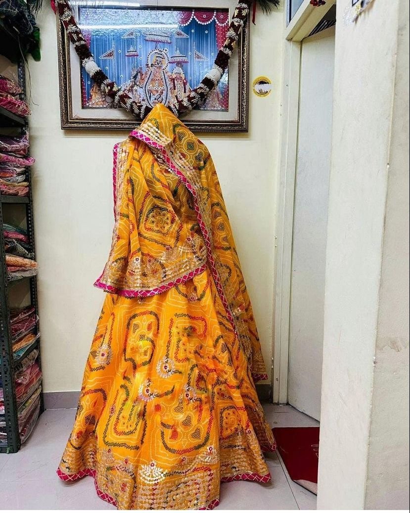 Bandhani Lehenga, Kota Doria Bandhani Lehenga with Gota Patti 7 A red and yellow Bandhani lehenga with Gota Patti work displayed on a mannequin.