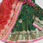 A red and yellow Bandhani lehenga with Gota Patti work displayed on a mannequin.