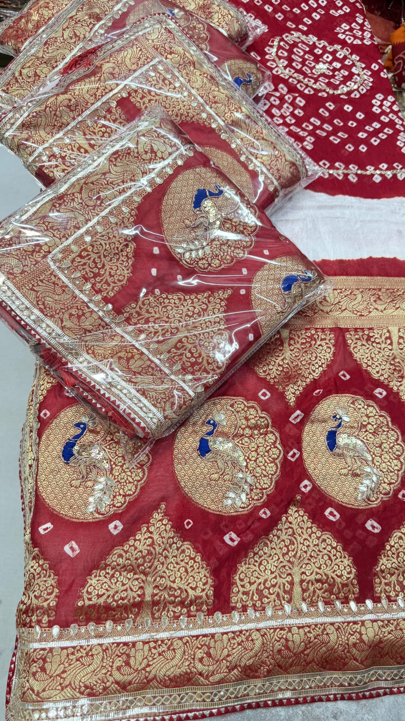 Red Bandhej Georgette Saree With Hand Gota Patti Work 1 A vibrant red Bandhej georgette saree featuring detailed gold Gota Patti peacock motifs and borders.