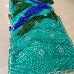 A beautiful semi silk Bandhej saree in shades of green and blue, featuring intricate Gota Patti and Katdana handwork throughout the fabric.