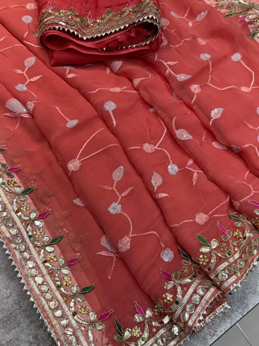 New Arrivals 44 A beautiful coral-toned pure chiffon saree with intricate golden Gota Patti and Kundan handwork, displayed with its matching blouse piece.