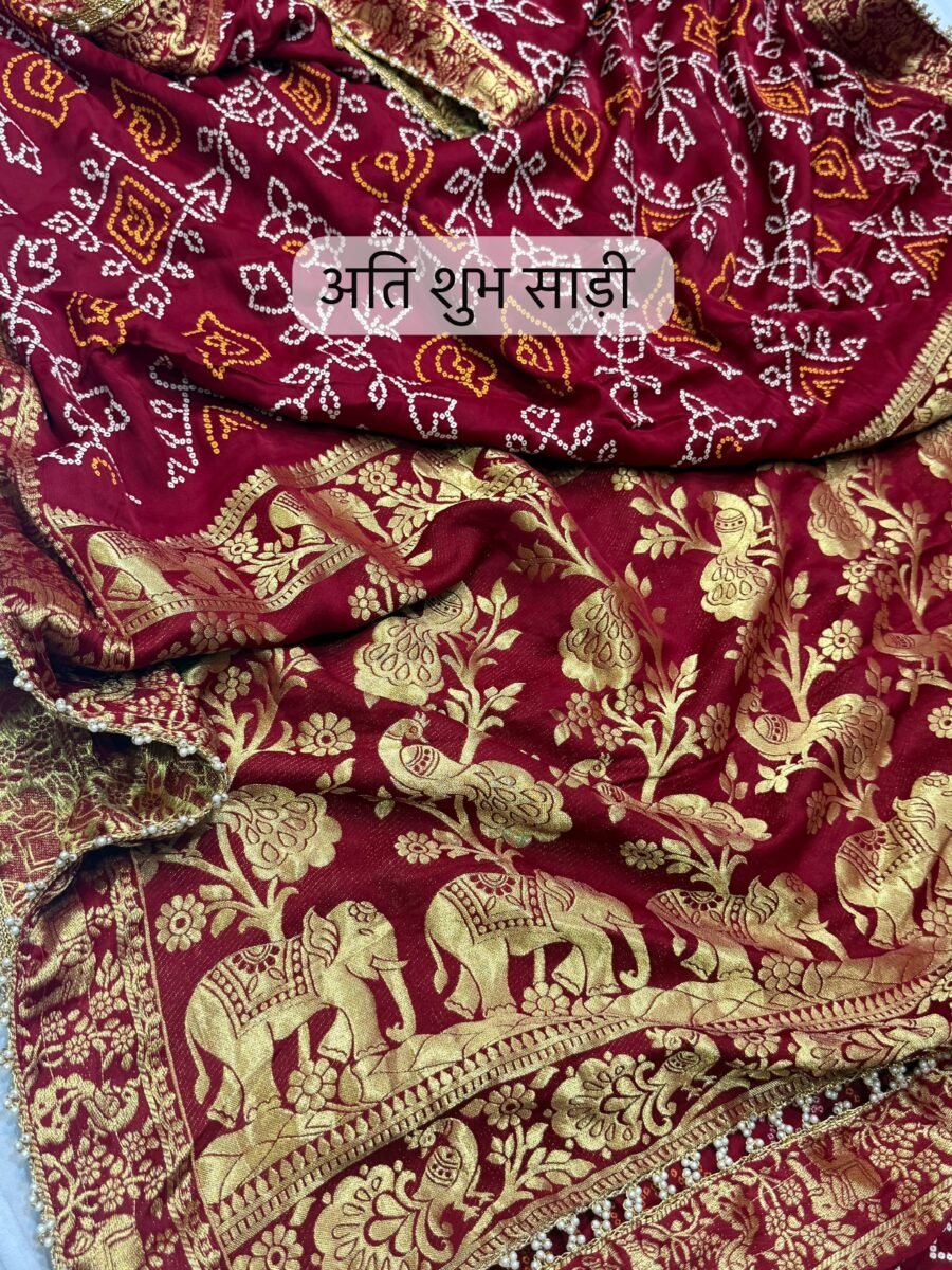 A close-up view of a rich red Pure Gajji Silk saree featuring detailed white hand Bandhej print, gold elephant zari motifs, and a pearl-accented gota border.