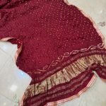 Three colorful Bandhej dupattas with Gota Patti borders and tassels displayed on a light surface.