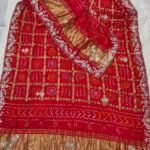 A red pure Gajji silk Bandhej dupatta with gold zari checks, heavy gota patti border, and a rich zari pallu.