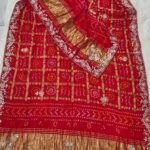 A red pure Gajji silk Bandhej dupatta with gold zari checks, heavy gota patti border, and a rich zari pallu.