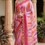 A beautiful collection of multicolored georgette sarees with dabka gota patti work displayed on a table.