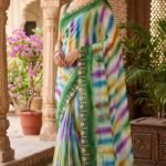 A beautiful collection of multicolored georgette sarees with dabka gota patti work displayed on a table.