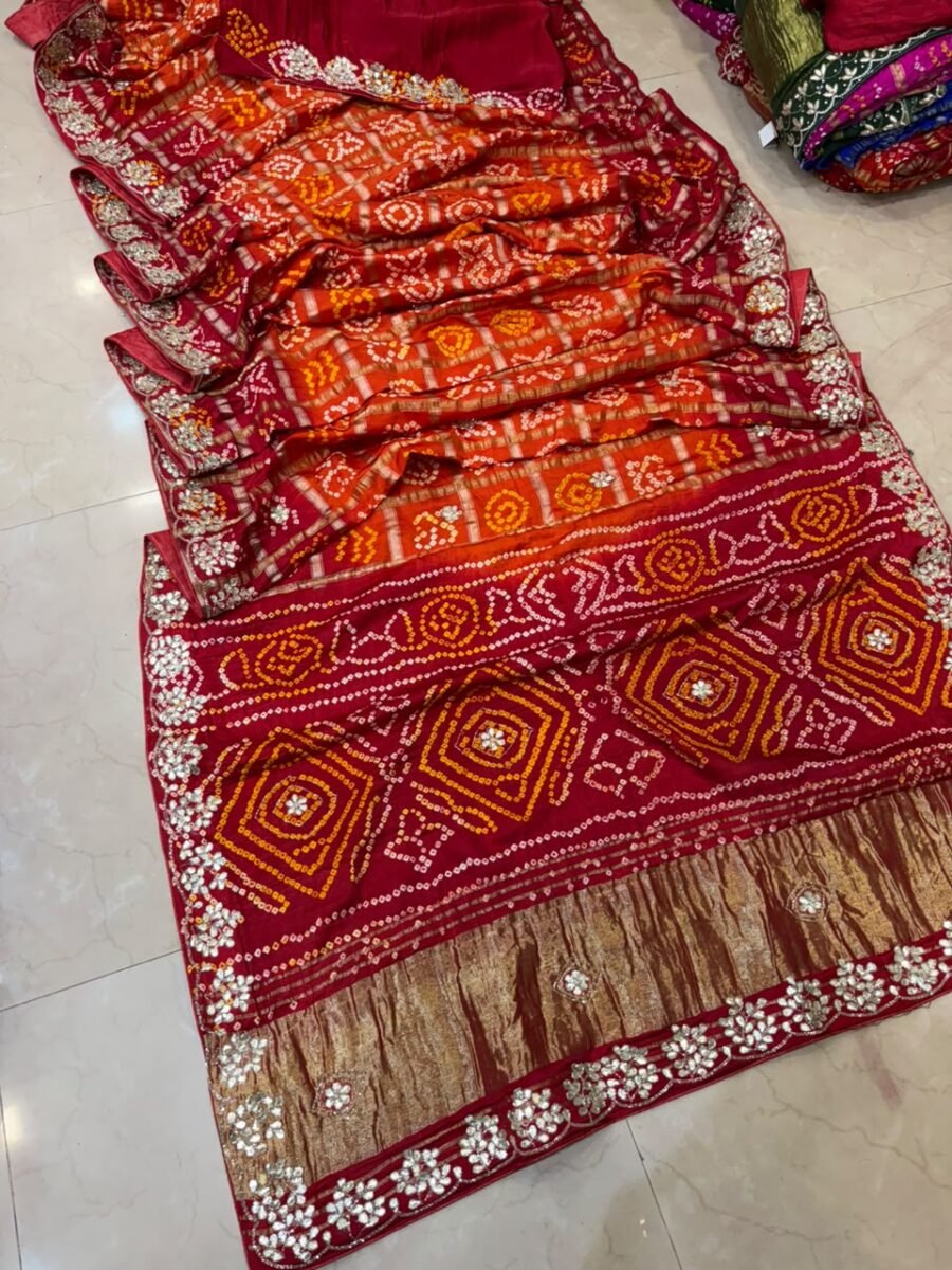 A luxurious red and orange Ghadchola silk saree featuring detailed Gota Patti work and zari borders.