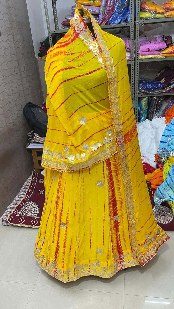 Gota Patti Lehenga | Bandhani Lehenga | Jaipuri Lehenga 8 A woman wearing a white and red shibori printed lehenga with heavy Aari Gota Patti work and a matching dupatta.