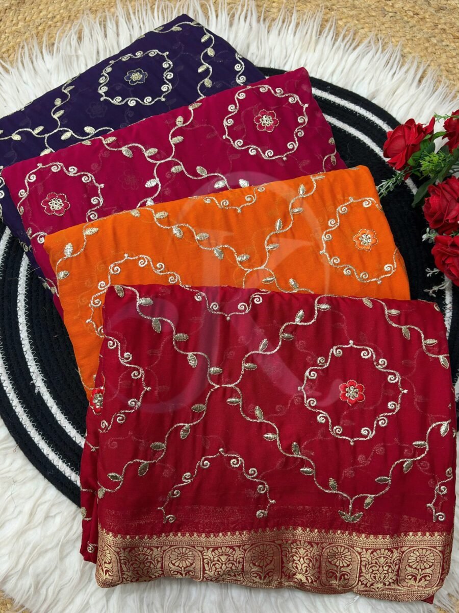A flat lay of four colorful sarees featuring gold Gota Patti work and Nazbin Jacquard borders arranged on a white fur rug.