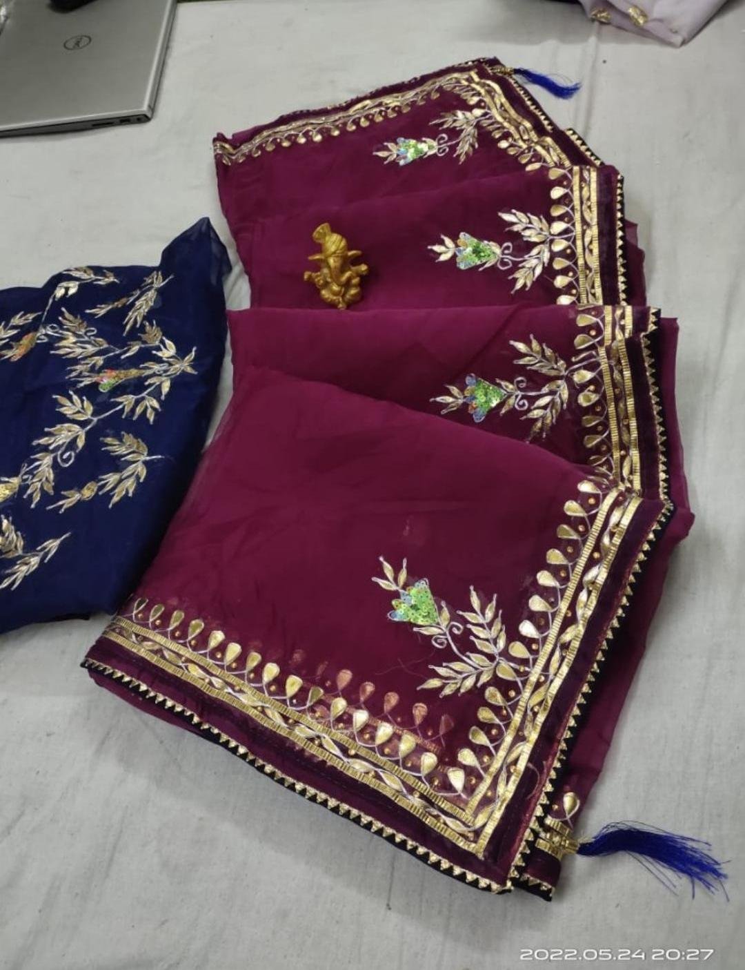 Organza Gota Patti Handwork Saree 3 A beautiful deep purple Organza saree with detailed gold Gota patti handwork and a contrasting bright blue blouse piece.